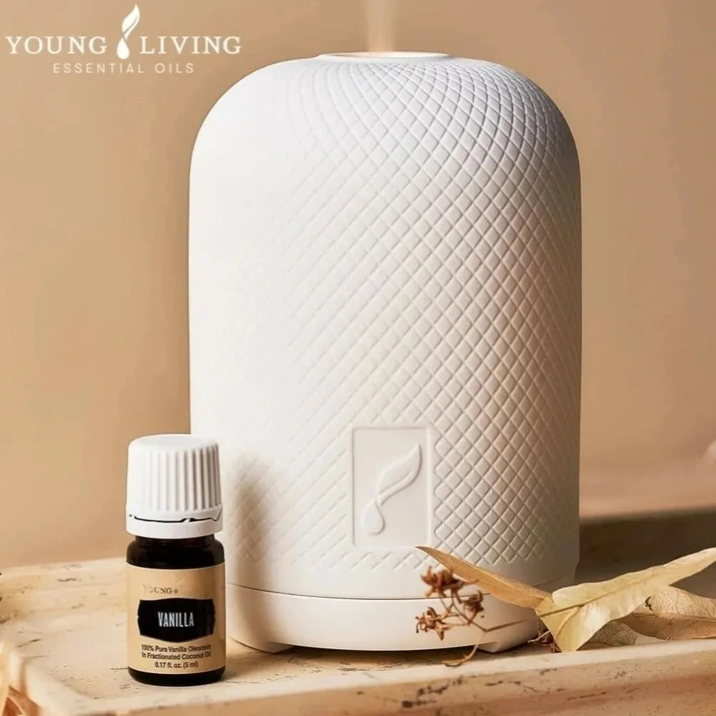 Premium Young Living diffuser met Vanilla essentiële olie op een houten blad – een stijlvolle en natuurlijke manier om rust te creëren in huis.