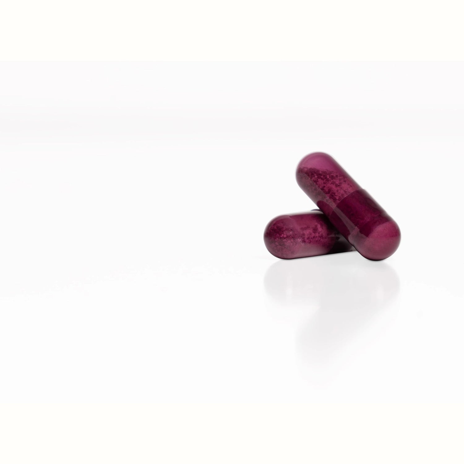 Close-up van twee paarse Illumineyes capsules – rijk aan antioxidanten voor ooggezondheid, celbescherming en DNA-herstel.
