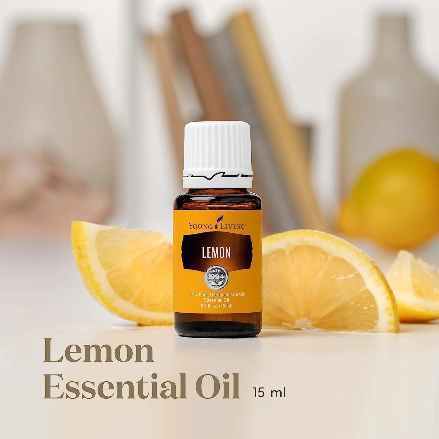 Young Living Lemon Essential Oil 15 ml op houten ondergrond met citroenschil – zuiverende etherische olie voor detox, focus en een frisse start van de dag.