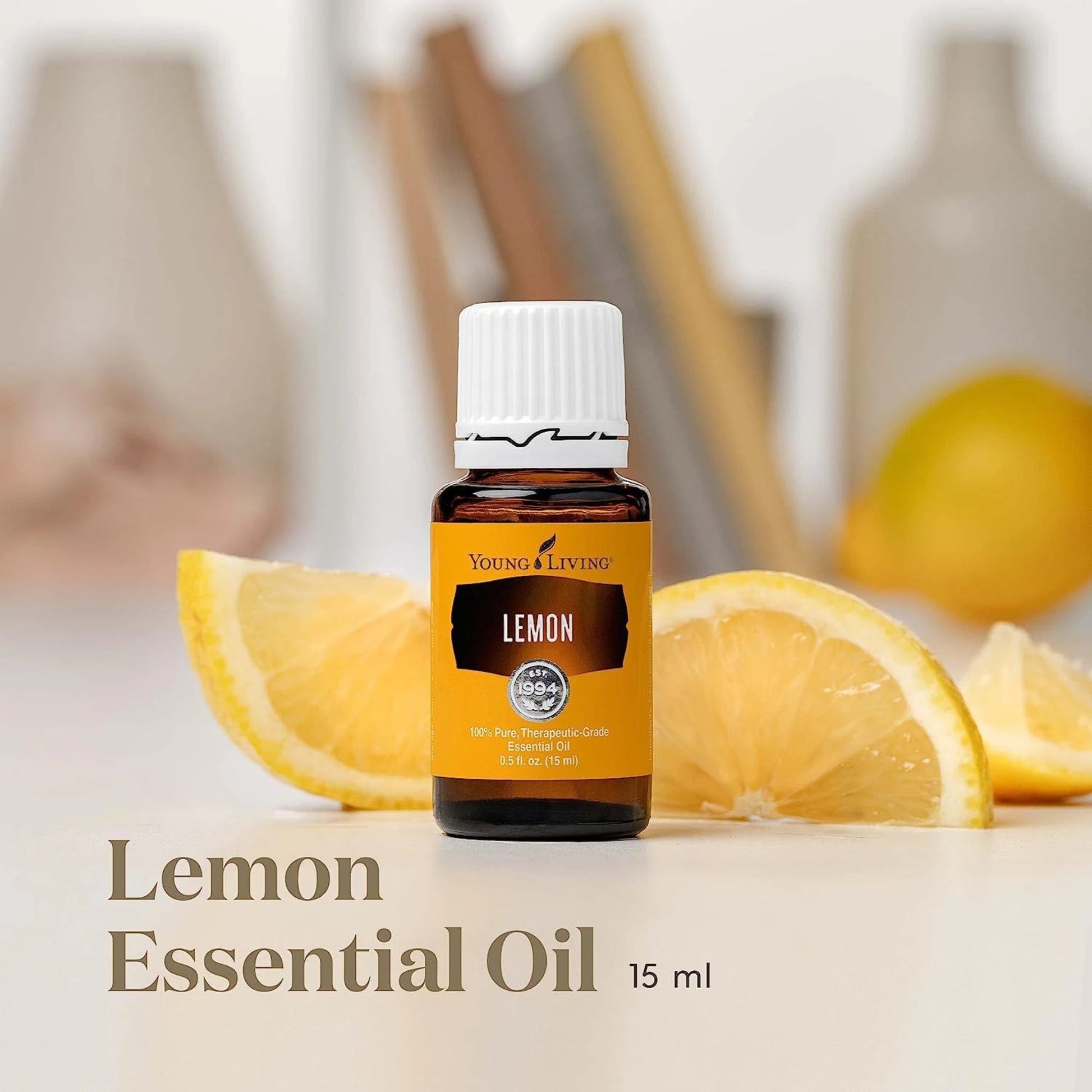Young Living Lemon Essential Oil 15 ml op houten ondergrond met citroenschil – zuiverende etherische olie voor detox, focus en een frisse start van de dag.