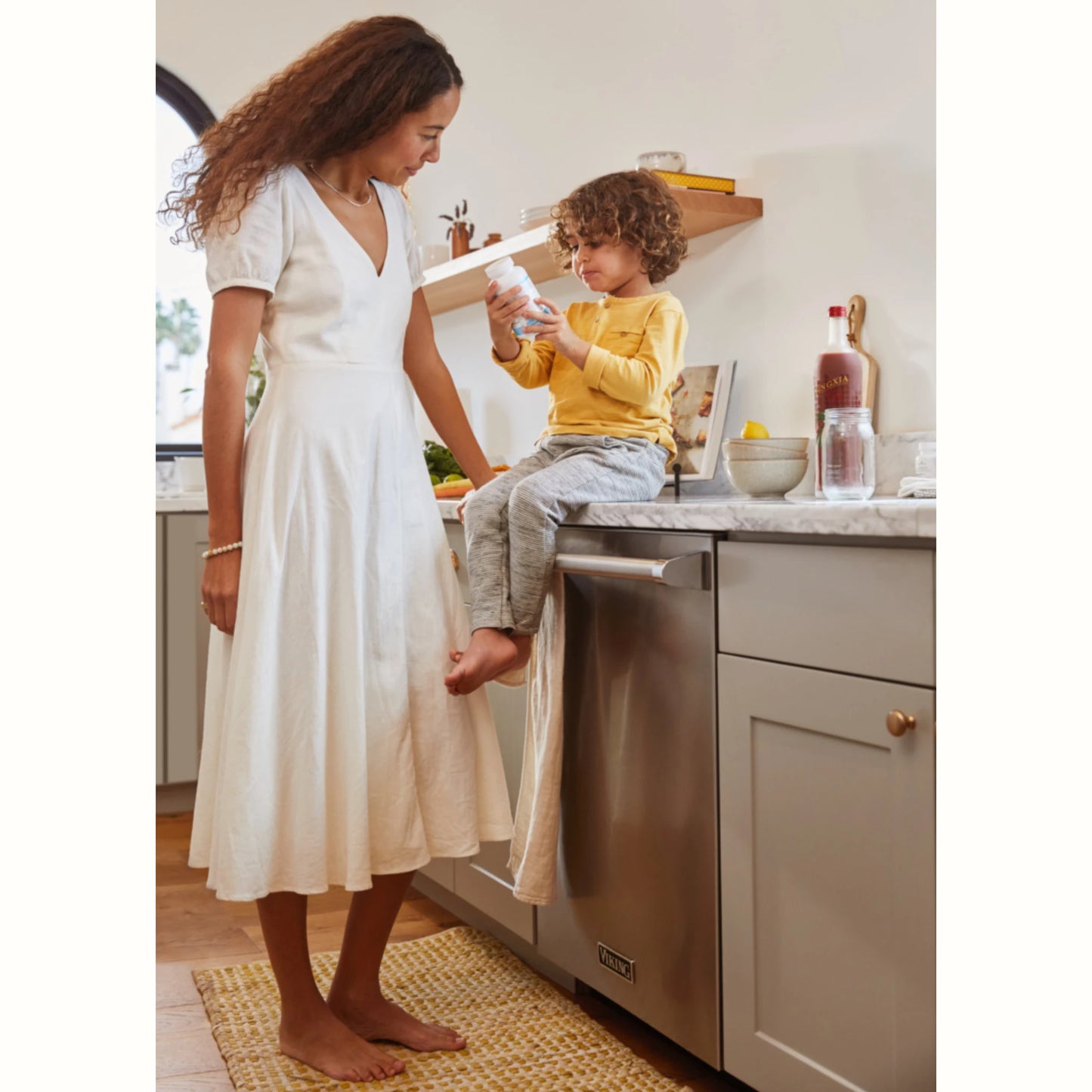 Moeder met kind in keuken, met NingXia Red op het aanrecht – natuurlijke wellnessdrank voor kinderen en gezinnen ter ondersteuning van weerstand, energie en gezonde gewoontes.