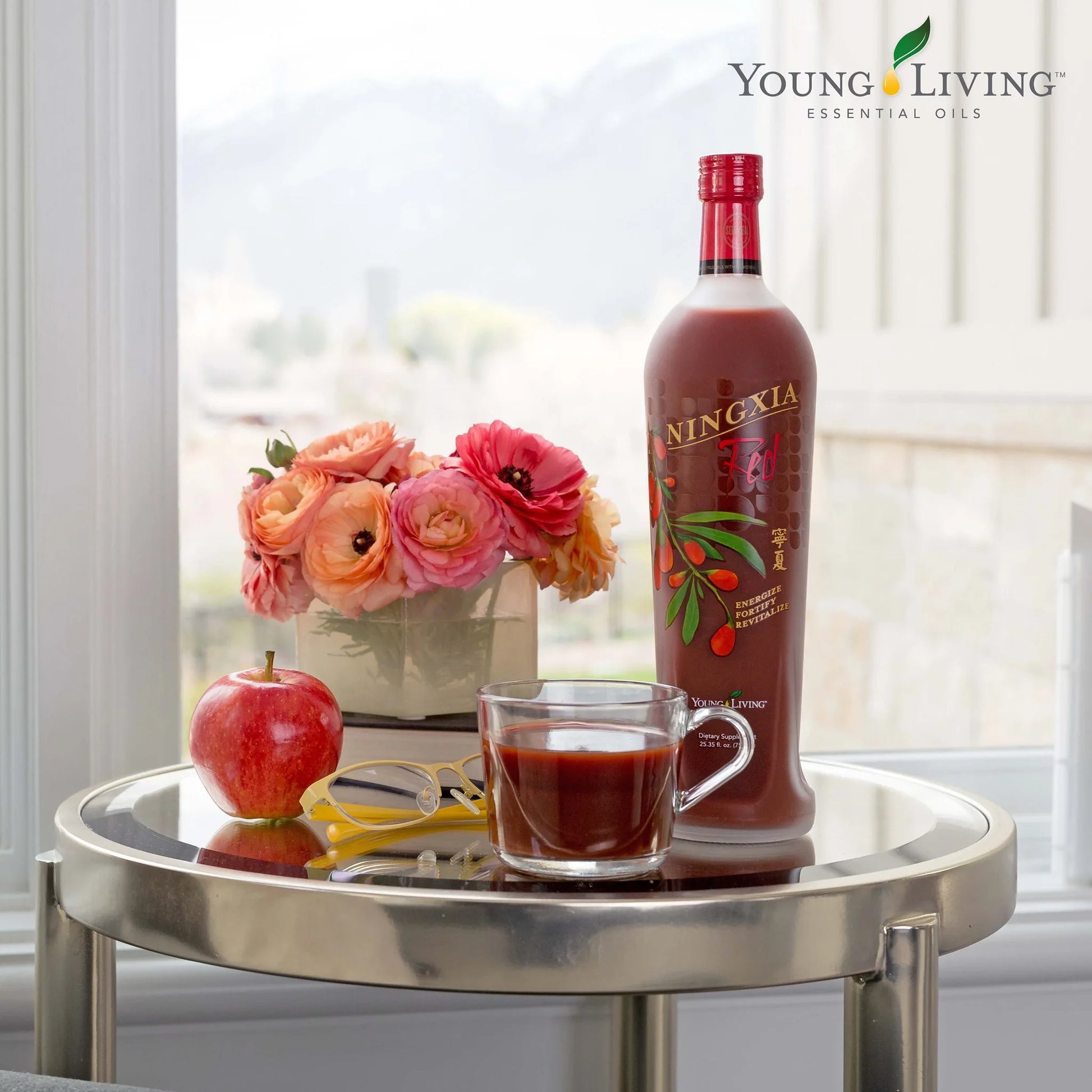 NingXia Red glas en fles bij een boeket bloemen – ideaal voor een verwenmoment vol natuurlijke energie en zomerse wellness.