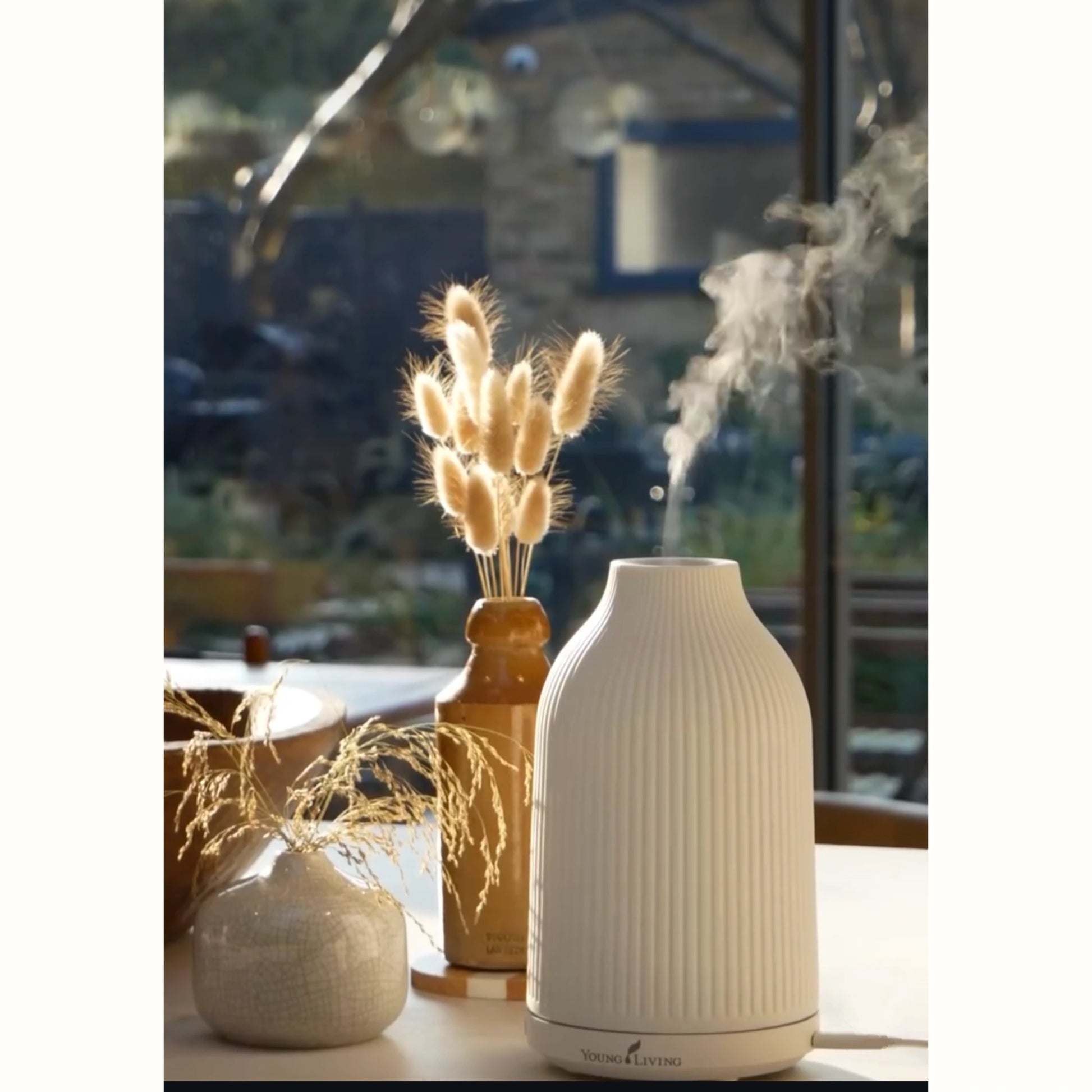 Keramische Young Living diffuser die zachte stoom verspreidt in een rustgevende interieursetting, ideaal voor ontspanning bij overprikkeling, spanningshoofdpijn of hormonale disbalans.