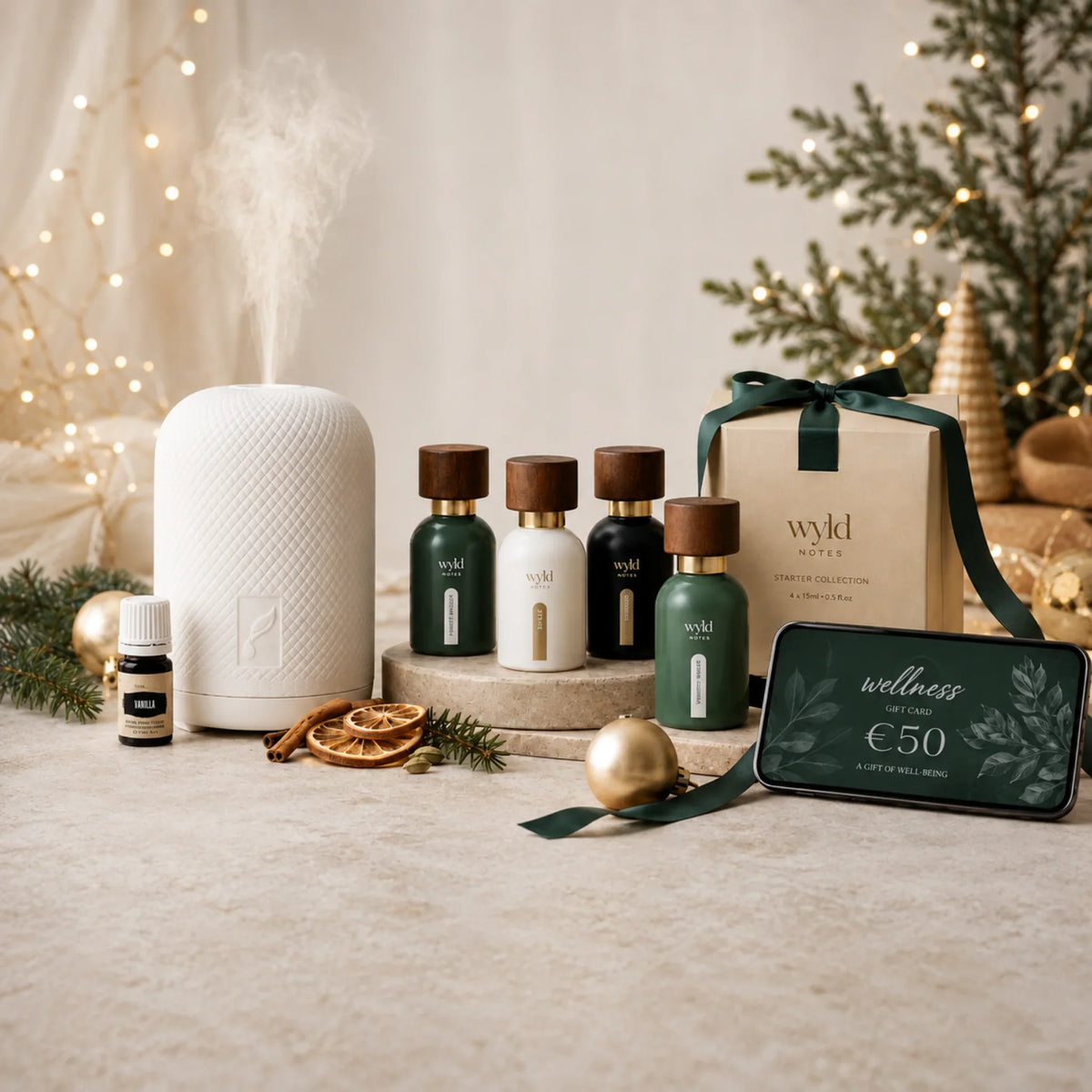Kerstsfeer met parfum, diffuser, starterbundel en digitale wellness giftcard tussen groene dennentakken en gouden kerstdecoratie.