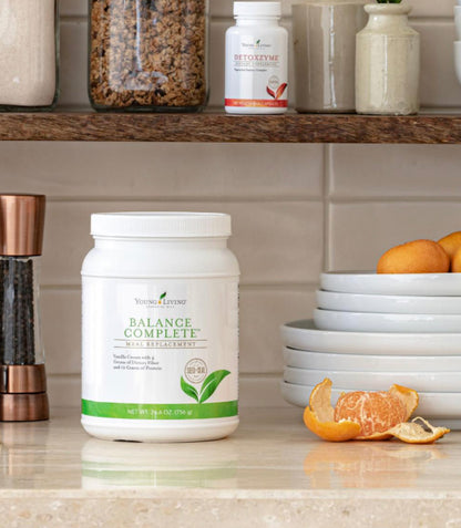 Young Living Balance Complete maaltijdvervanger op een keukenblad met fruit en servies – voedzame shake met proteïne en vezels voor een gebalanceerde levensstijl.