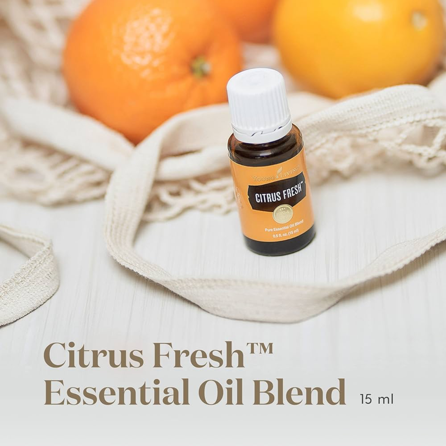 Citrus Fresh essentiële olie van Young Living in een netzak met sinaasappels – perfecte olie voor natuurlijke detox en energieboost bij drukke vrouwen