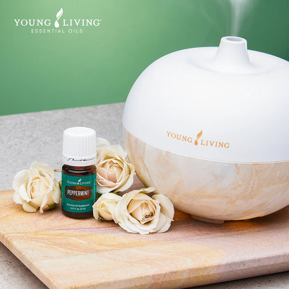 Diffuser van Young Living met Peppermint essentiële olie en verse rozen, perfect voor een verfrissende en opbeurende aromatherapie-ervaring thuis.