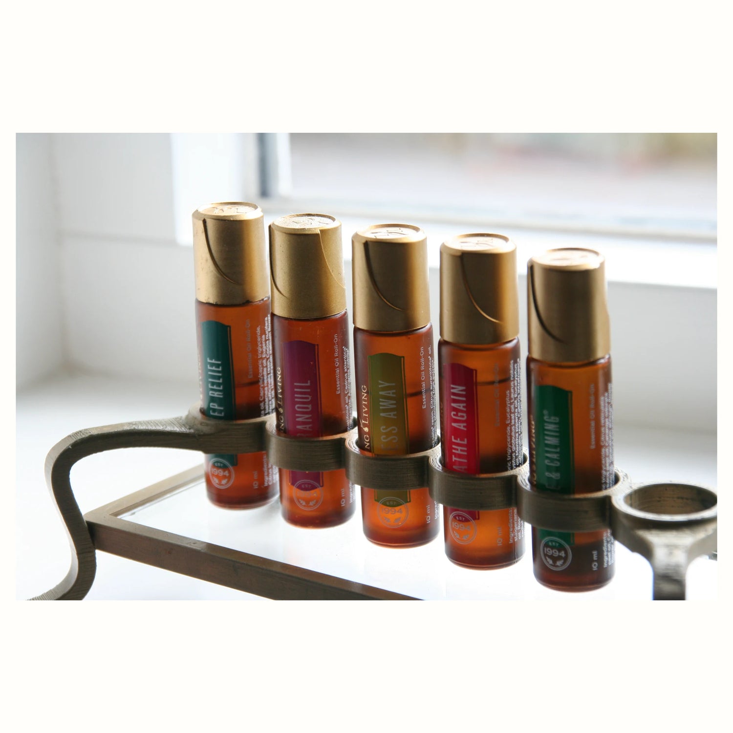 Close-up van 5 handige essentiële olie roll-ons van Young Living, perfect voor vroege ochtenden, lange dagen en zware workouts. Natuurlijke ondersteuning voor energie en balans.