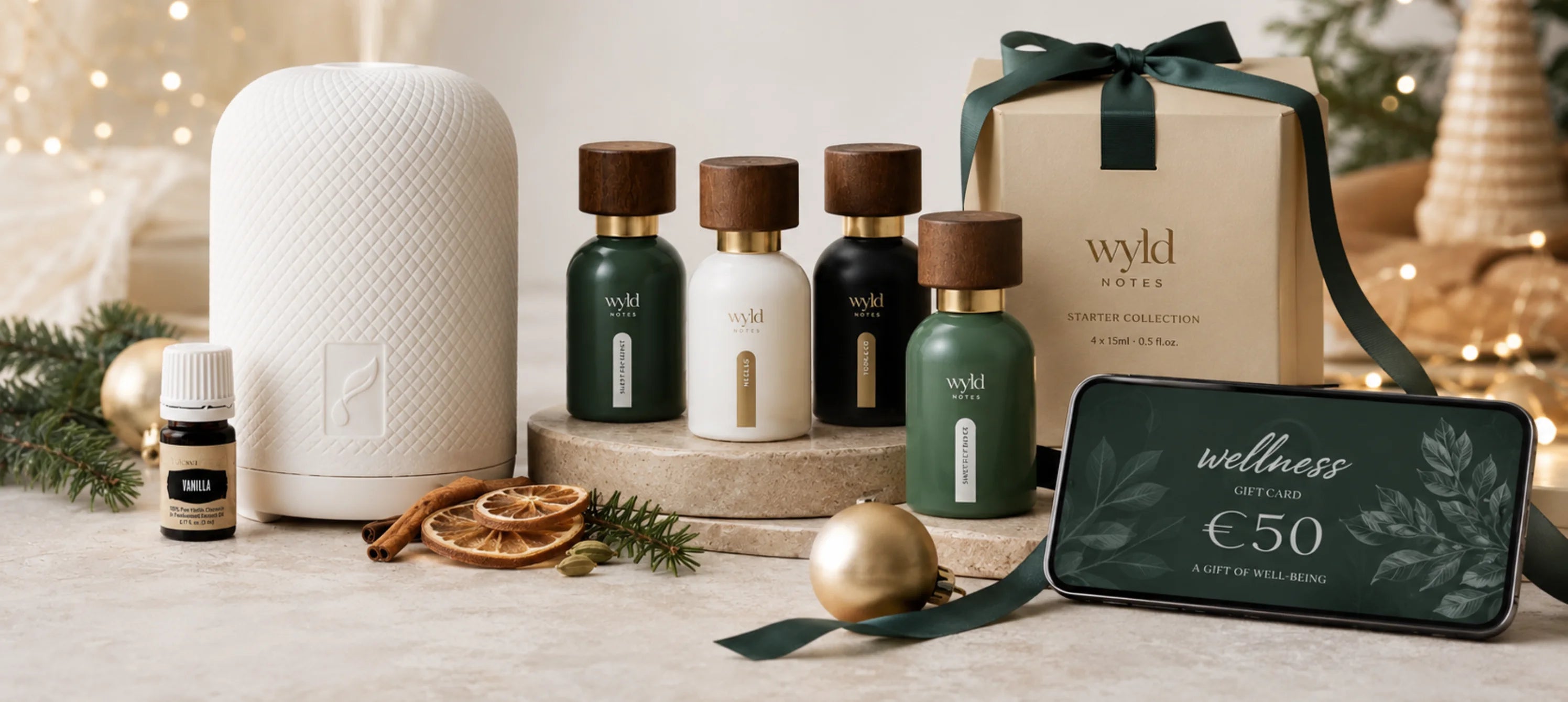 Hero banner in Kerstsfeer met parfum, diffuser, starterbundel en digitale wellness giftcard tussen groene dennentakken en gouden kerstdecoratie.