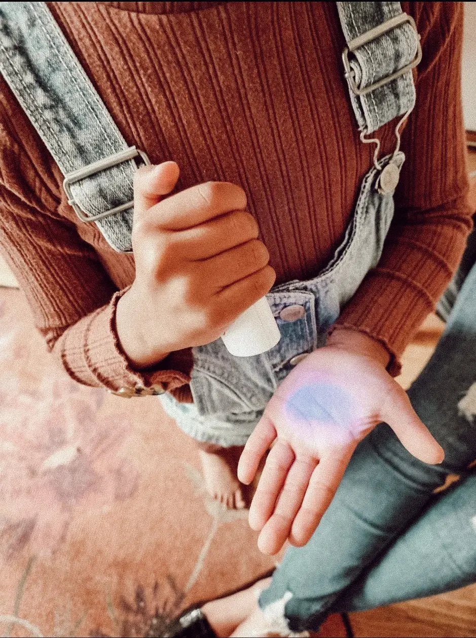 Kind houdt de iTOVi scanner in haar hand tijdens een meting, een zachte en speelse manier om inzicht te krijgen in emotionele en lichamelijke ondersteuning met essentiële oliën 🌿✨