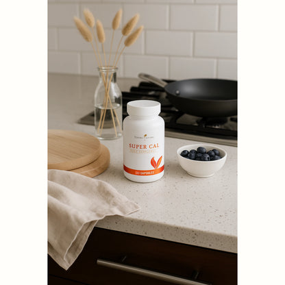 Super Cal supplement van Young Living op een houten schaal met natuurlijke decoratie en rustgevende texturen – perfect voor ontspanning en ondersteuning van het zenuwstelsel.