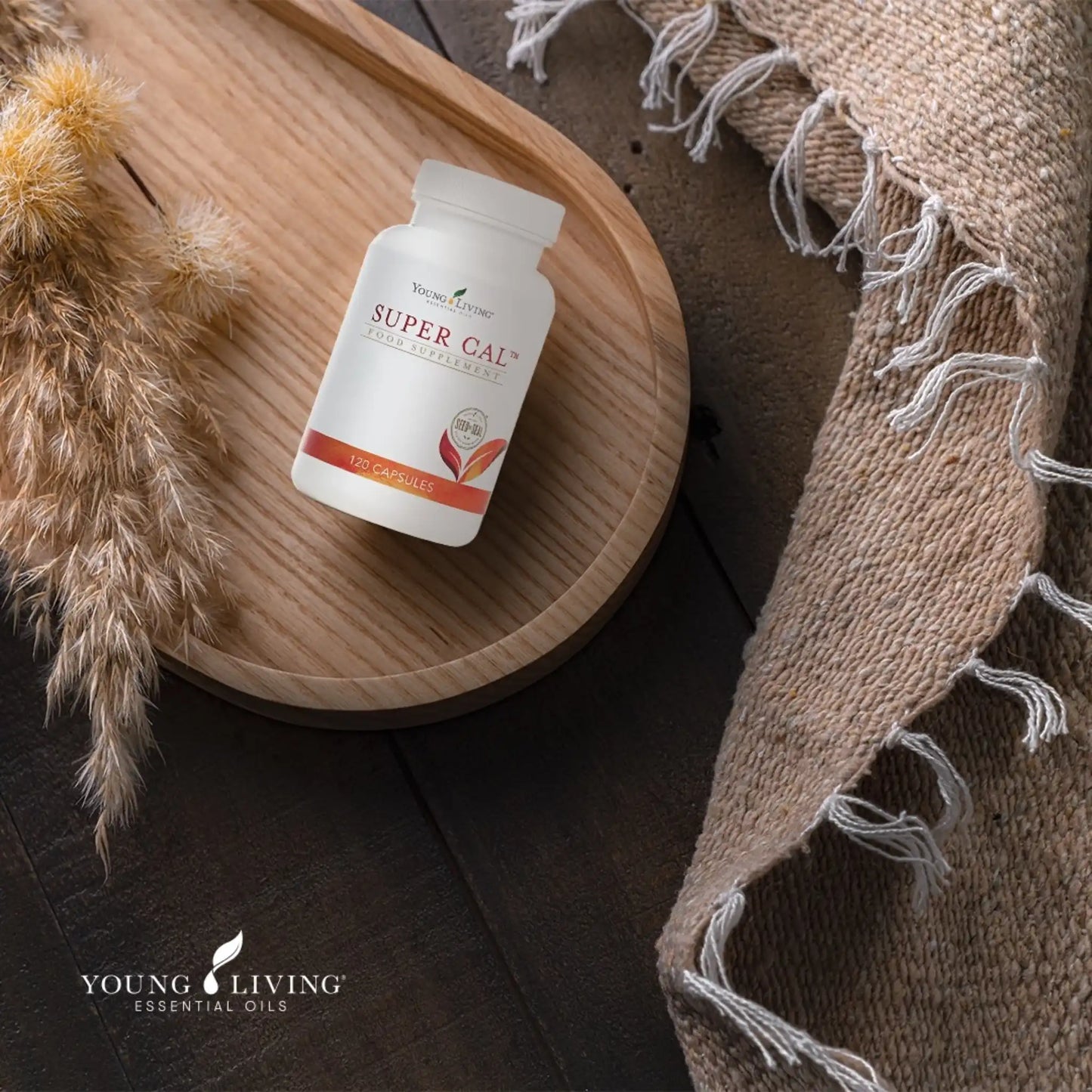 Pot Super Cal van Young Living op houten plateau met rustgevende texturen – ondersteunt ontspanning en helpt het zenuwstelsel kalmeren.