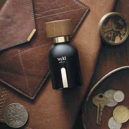 Wyld Notes Black Book parfum op donker leer met kompas, sleutels en old money uitstraling.